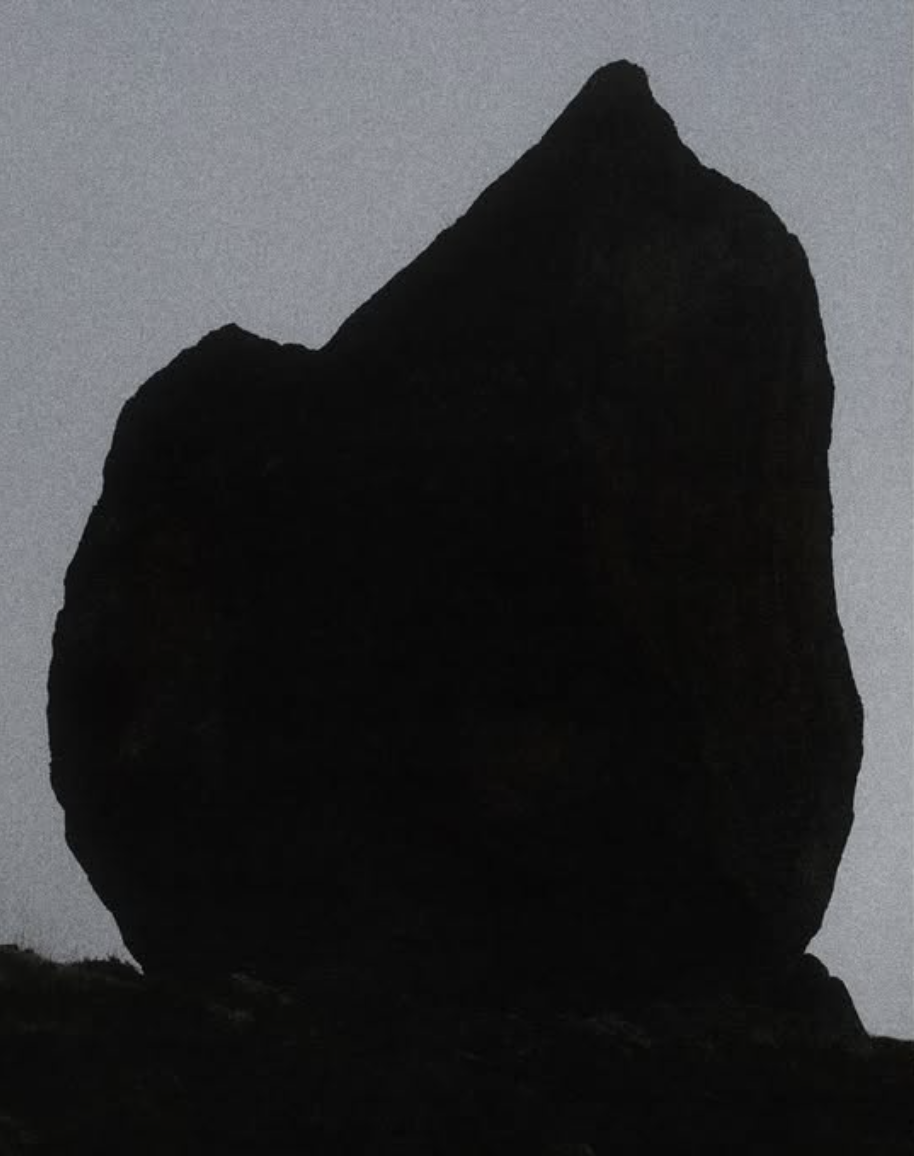 Dark monolith against a pale sky